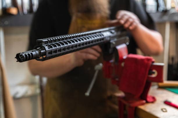 Gunsmith repairing a firearm at the bench